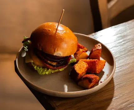 Hamburguesa de carne con papas gajo de guarnición en Chambao Madrid
